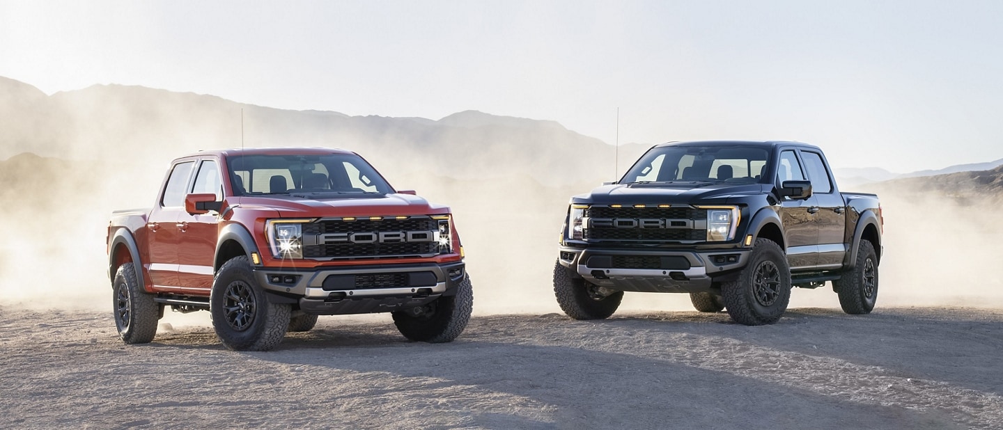 Two 2023 Ford F-150® Raptor® trucks parked in the desert