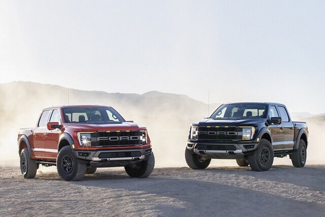 Two 2023 Ford F-150® Raptor® trucks parked in the desert