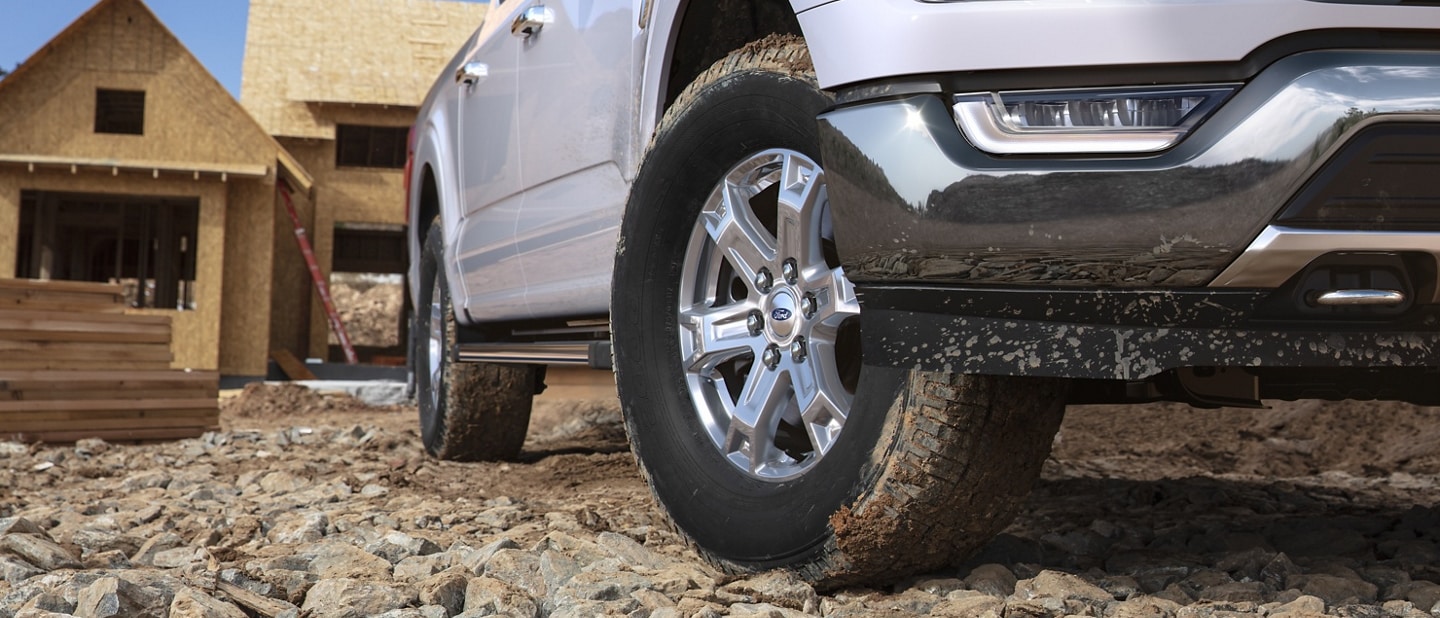 Close-up on the front wheel of a 2023 Ford F-150® parked at new home construction site
