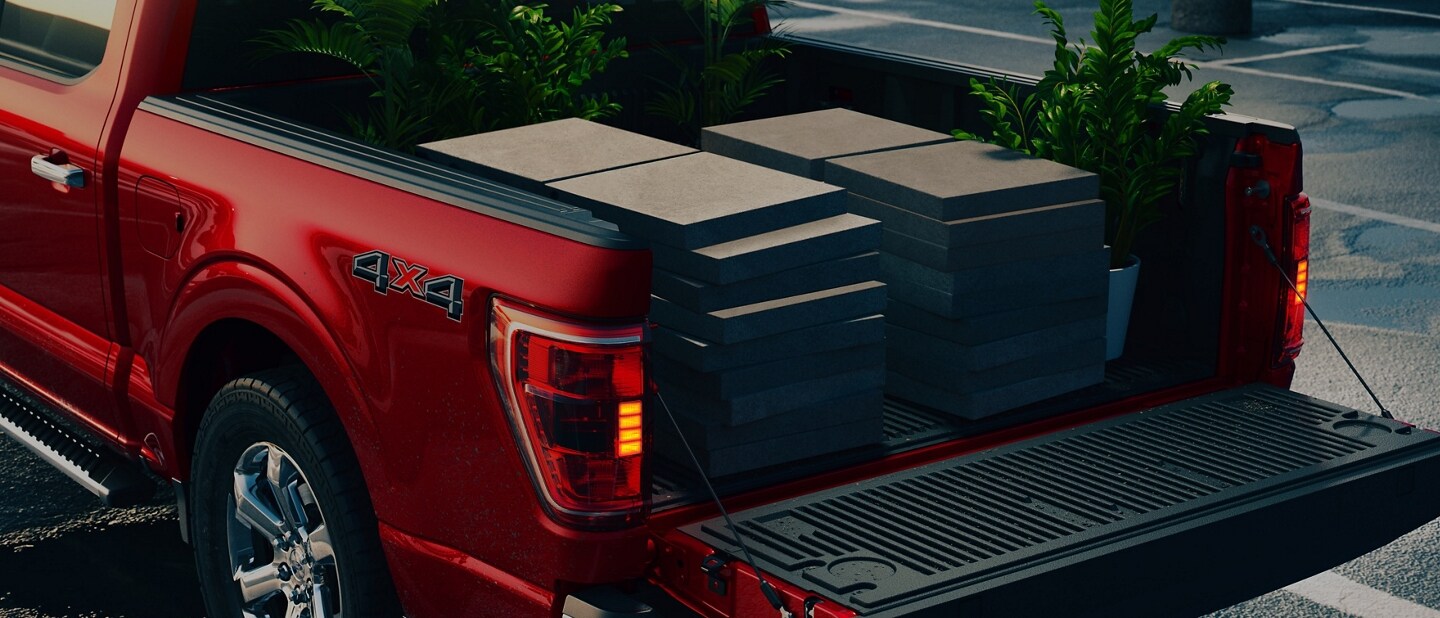 Close-up of a 2023 Ford F-150® pickup with tailgate down and paver blocks in the truck bed