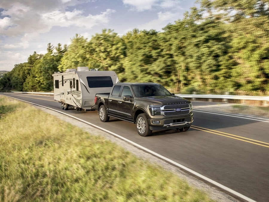 2024 Ford F-150® Platinum Plus in Agate Black pulling a camper trailer