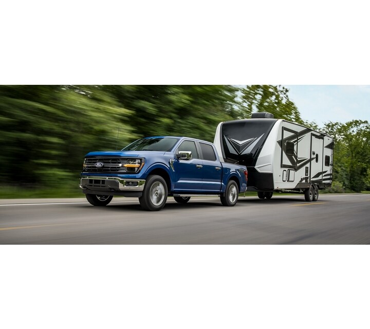 2024 Ford F-150® XLT in Atlas Blue pulling a camper trailer