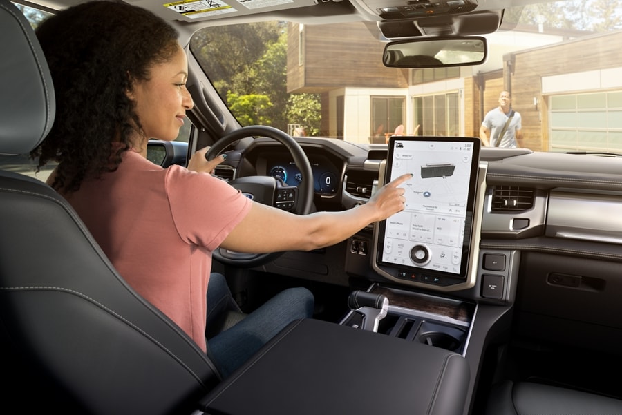 Interior image of a woman using the touchscreen of the centre display screen