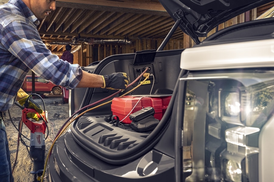 Man plugging in power tool cords to the Pro Power Onboard of 2023 Ford F-150® Lightning®