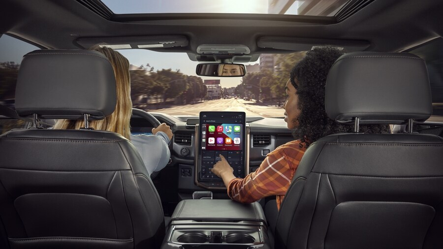Interior shot of 2023 Ford F-150® Lightning® with passenger interacting with touchscreen