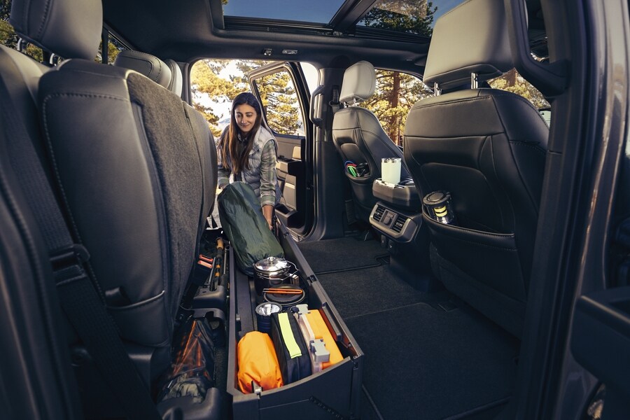 Woman loading items into the under-seat storage compartment