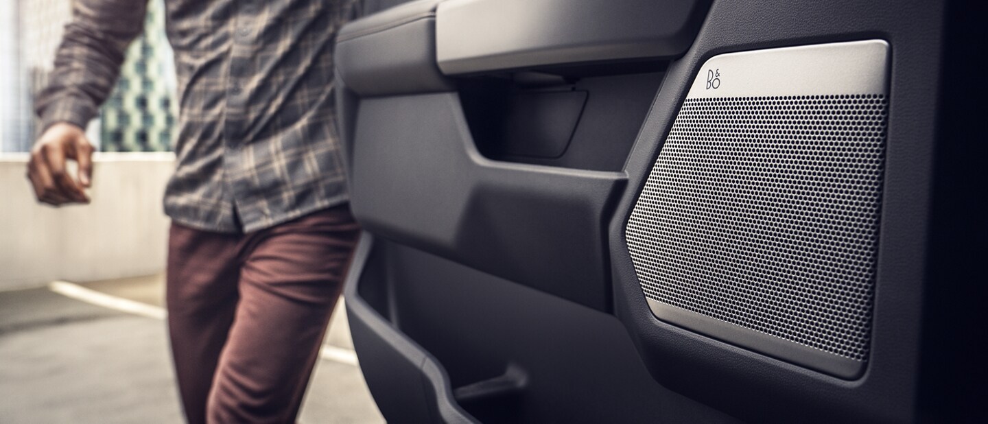 Man opening the rear door showing the door speaker