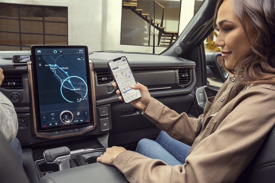Interior of a 2023 Ford F-150® Lightning® shows passenger connecting phone to the display screen