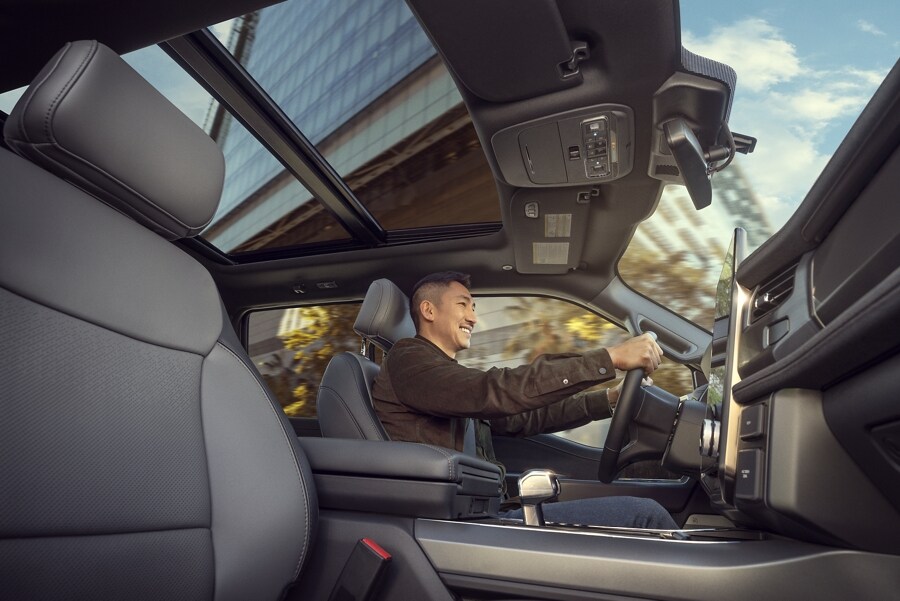 Interior of a 2023 Ford F-150® Lightning® with smiling man driving