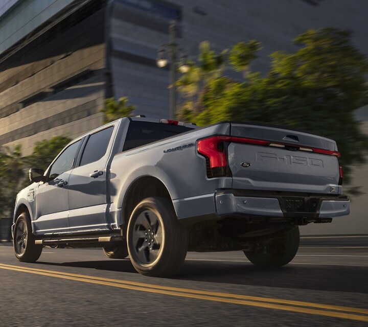 A 2023 Ford F-150® Lightning® driving down a city road