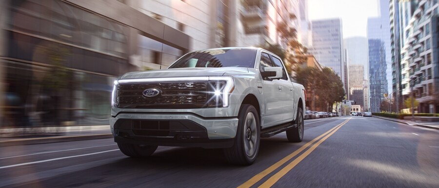 A 2023 Ford F-150® Lightning® Platinum edition being driven down a city road