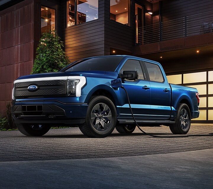 2023 Ford F-150® Lightning® Platinum in driveway at home, plugged into charger