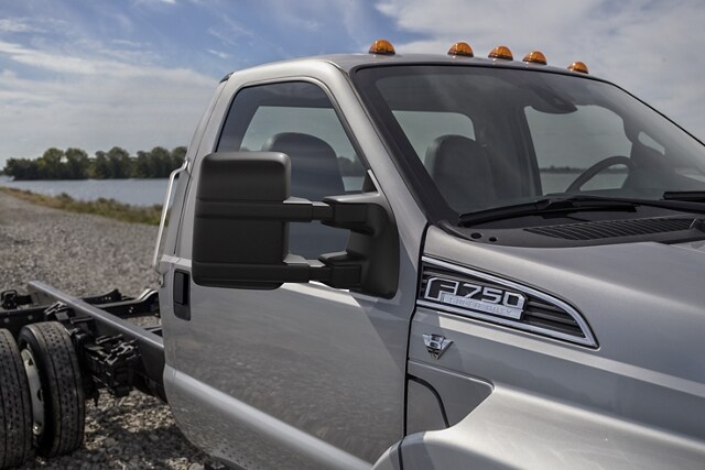 Close-up of the mirrors of a 2023 Ford F-750 Regular Cab in Ingot Silver parked on dirt path near water