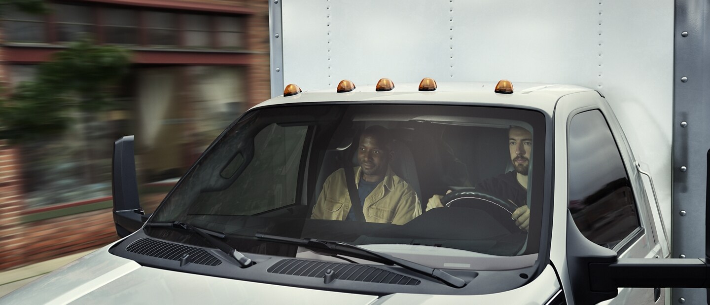 Driver and passenger seen through 2023 Ford F-750 windshield
