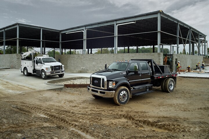 2023 Ford F-750 SuperCab in Oxford White and 2023 Ford F-750 Crew Cab in Agate Black at work site