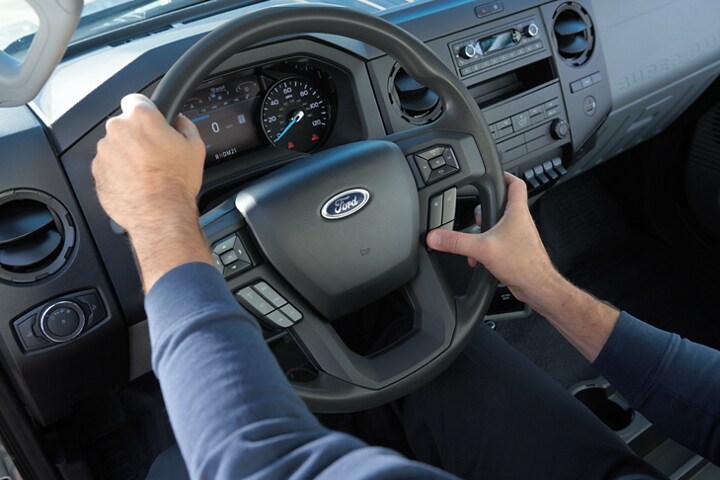 Hands using wheel-mounted controls on 2023 Ford F-750 steering column