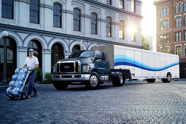 Person hauling water from 2023 Ford F-750 Crew Cab Tractor in Blue Jeans with beverage trailer