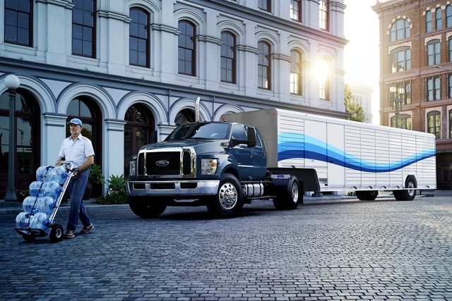 Man unloading water from 2023 Ford F-750 Crew Crab Tractor in Blue Jeans with Beverage Trailer