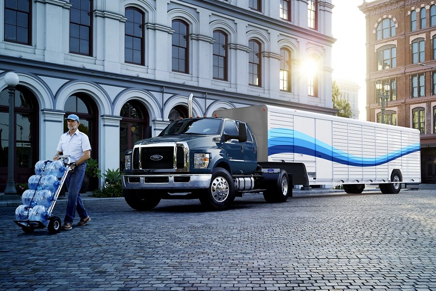 Man unloading water from 2023 Ford F-750 Crew Crab Tractor in Blue Jeans with Beverage Trailer