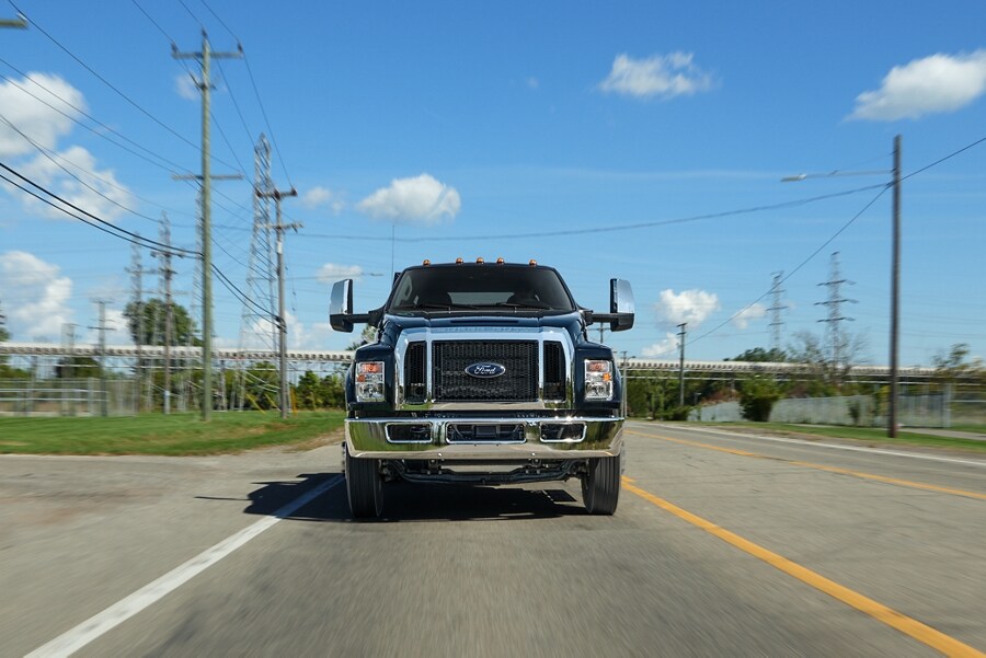 2024 Ford F-750 Crew Cab in Agate Black being driven on road near telephone lines