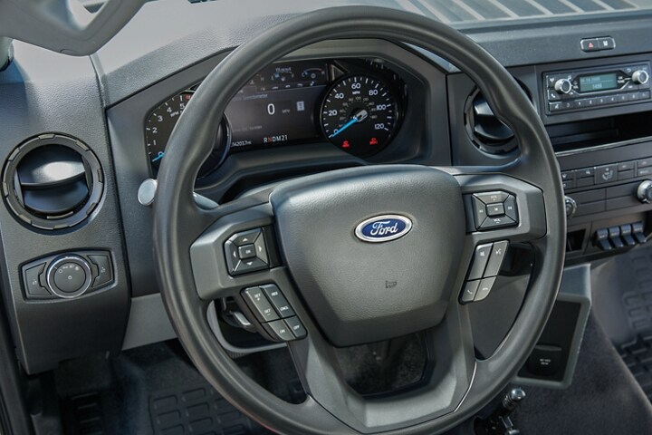 Close-up on 2025 Ford F-750® instrument panel cluster and tilt/telescoping steering wheel with integrated audio controls