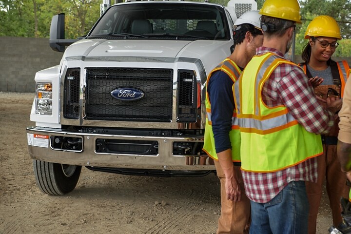Workers gathered in front of 2025 Ford F-750 SuperCab with mechanic truck upfit in Oxford White