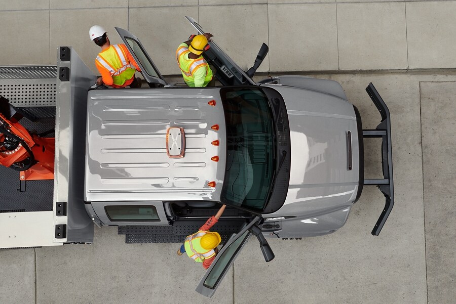 Aerial view of workers exiting 2025 Ford F-750 Crew Cab with aerial lift upfit in Iconic Silver
