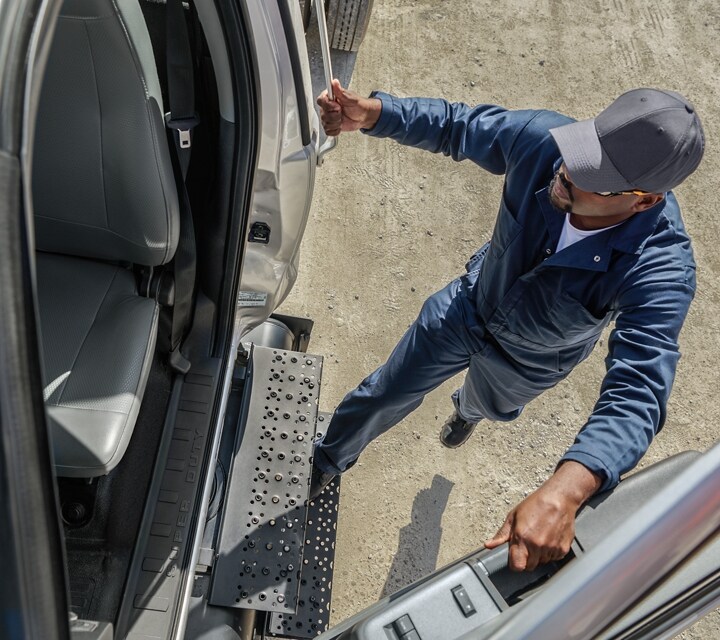 Driver entering 2026 Ford F-750® Regular Cab in Iconic Silver