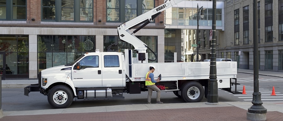 Workers changing city streetlights using 2026 F-750® Crew Cab with aerial lift upfit in Oxford White