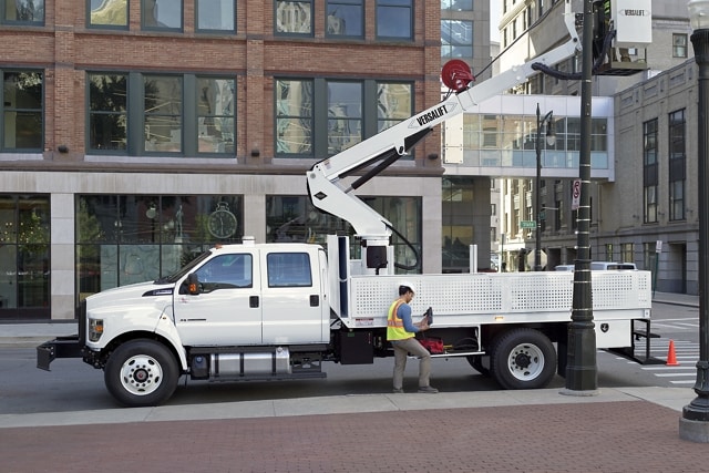 Workers changing city streetlights using 2026 Ford F-750® Crew Cab in Oxford White with aerial lift upfit