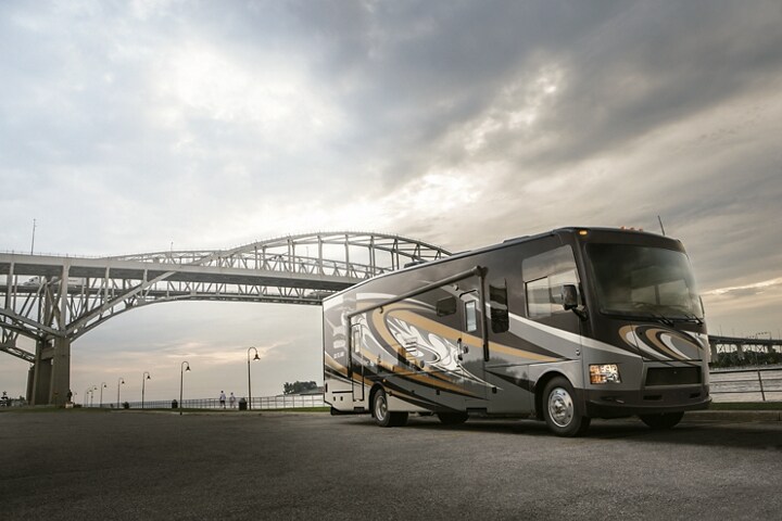 A Class A Motorhome on a 2024 Ford F-53 Stripped Chassis being driven under a bridge