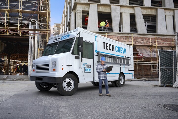 A 2024 Ford F-59 Stripped Chassis with walk-in delivery van body at a construction site