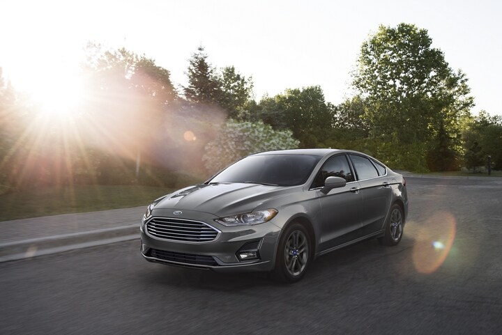 2020 Ford Fusion being driven on a suburban road while the sunset behind