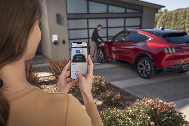 Woman using the FordPass® App to remotely control her 2023 Ford Mustang Mach-E®