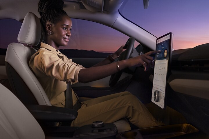 Woman using the 15.5" Touchscreen in a 2023 Ford Mustang Mach-E®