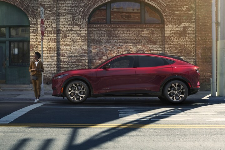 Woman standing in front of a 2023 Ford Mustang Mach-E® parked on the street