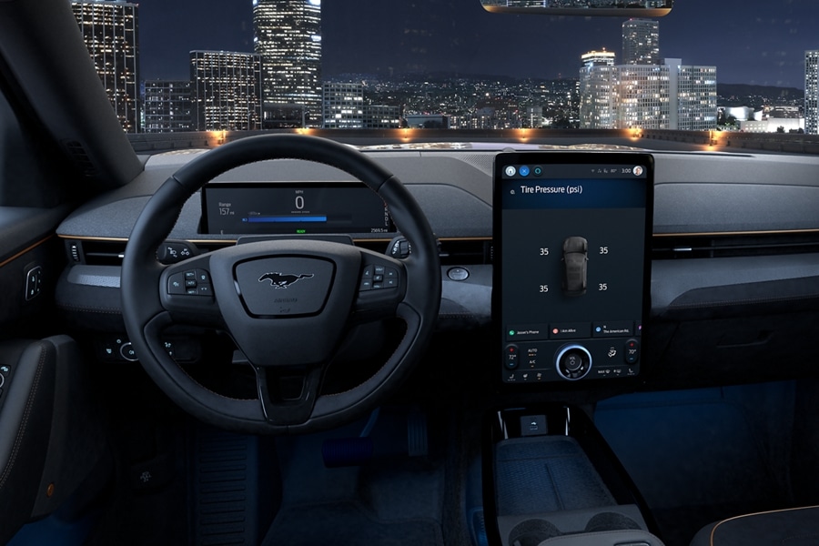 Interior of a 2023 Ford Mustang Mach-E® with nighttime city skyline visible through the windshield