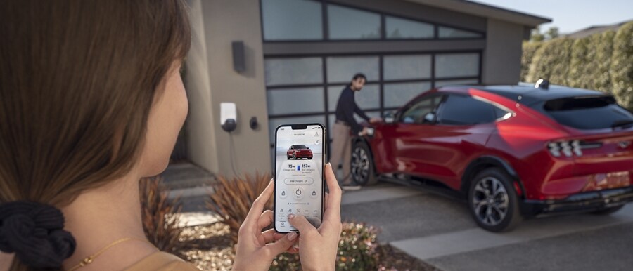 Woman using the FordPass® App to remotely control her 2023 Ford Mustang Mach-E®