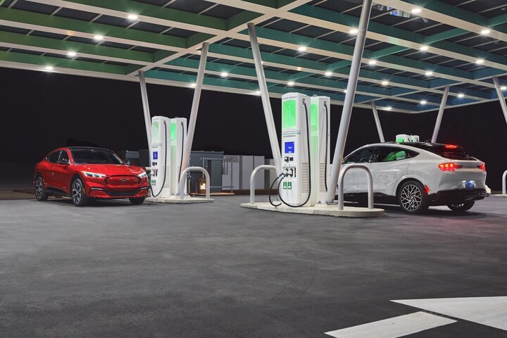 Two 2023 Ford Mustang Mach-E® SUVs parked at a charging station