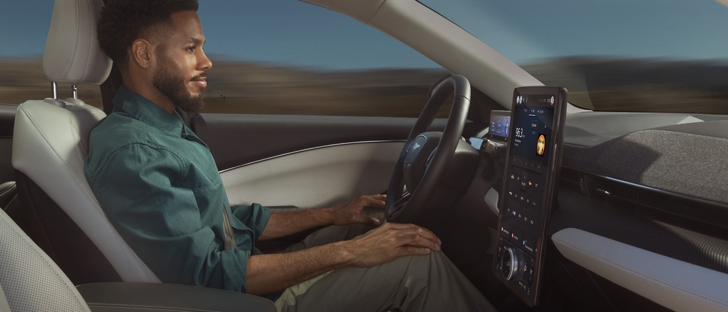 Man using Ford BlueCruise sitting in the driver’s seat of a 2023 Ford Mustang Mach-E® with hands on his knees