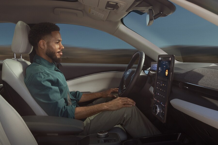Man using Ford BlueCruise sitting in the driver’s seat of a 2023 Ford Mustang Mach-E® with hands on his knees