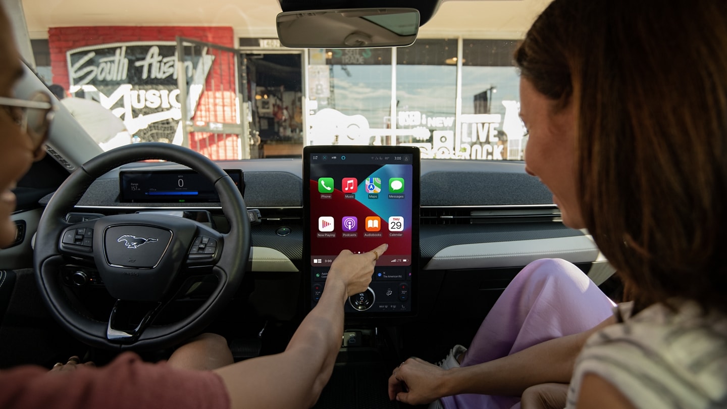 A person sitting inside a 2024 Ford Mustang Mach-E® using Apple CarPlay