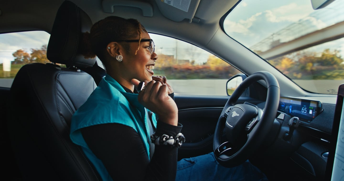A woman sitting inside a 2024 Ford Mustang Mach-E® and using BlueCruise