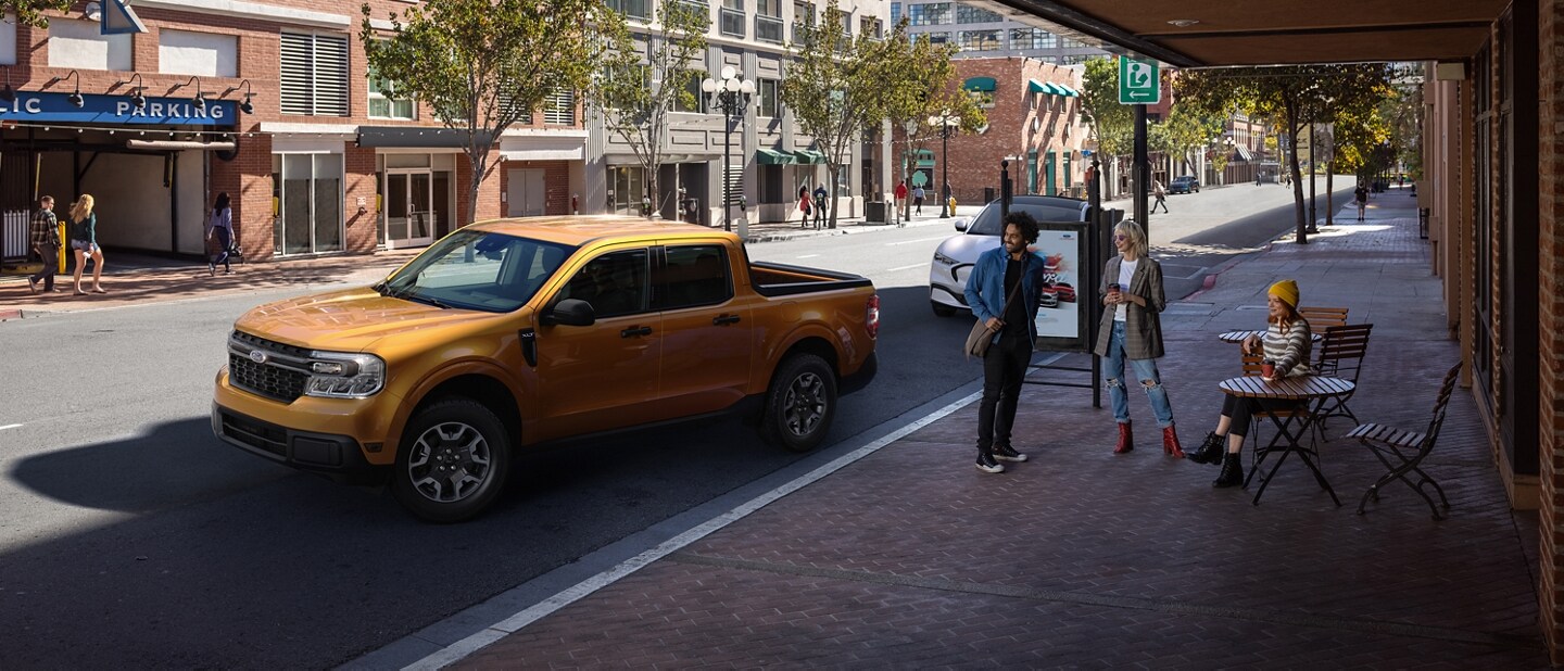 2023 Ford Maverick® XLT in Cyber Orange with Rear View Camera parallel parking outside a café