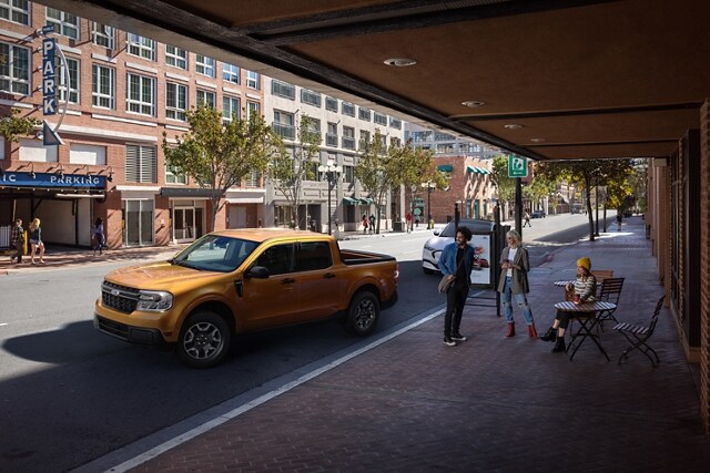 2023 Ford Maverick® XLT in Cyber Orange with Rear View Camera parallel parking outside a café