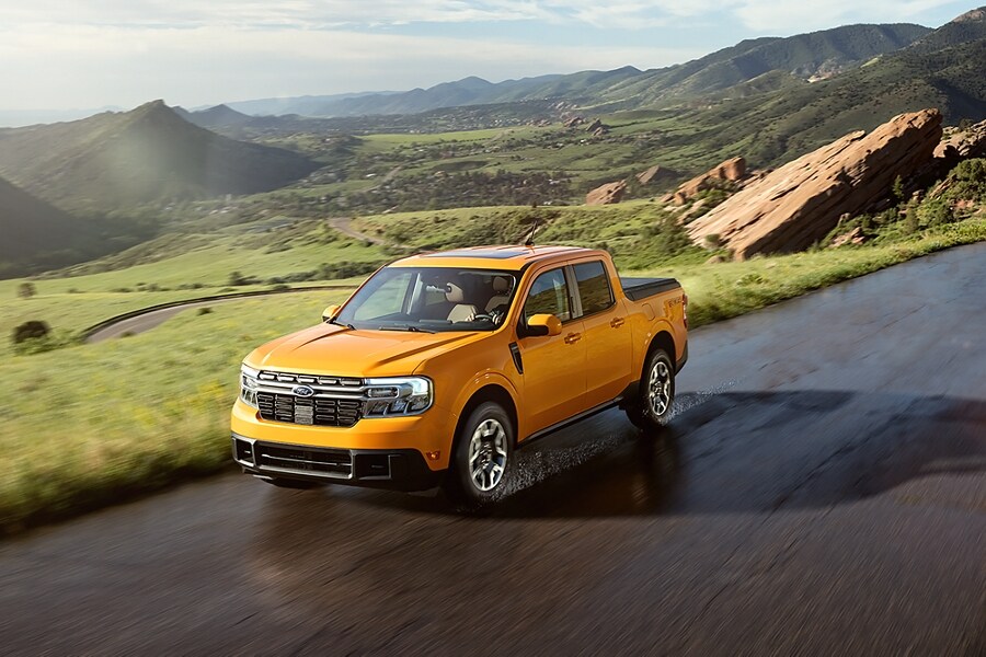 Cyber Orange 2023 Ford Maverick® truck on a road winding through a hilly, scenic landscape