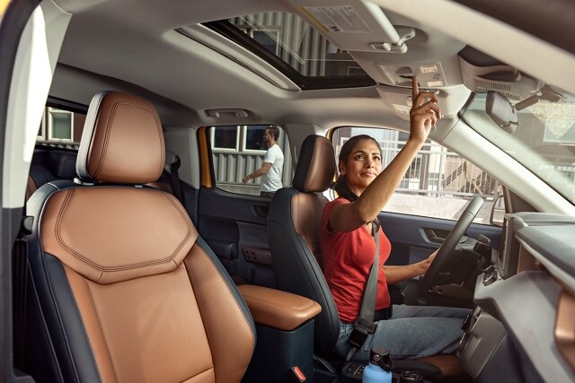 Woman operating the Power Moonroof inside the 2023 Ford Maverick® LARIAT truck