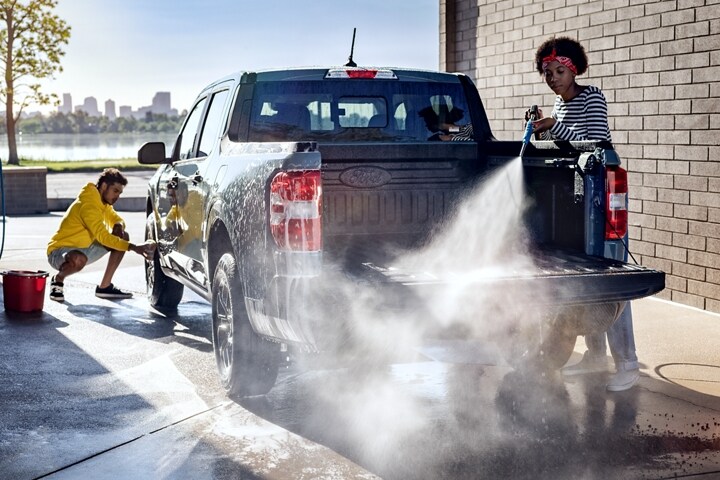 2023 Ford Maverick® truck in the colour Area 51 being hosed down and scrubbed by two people