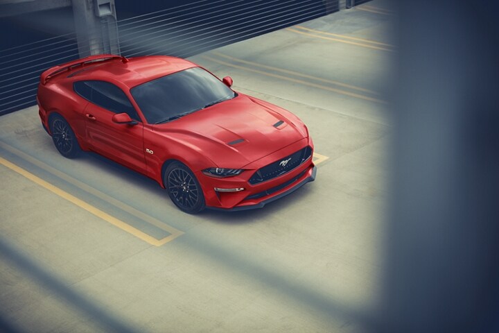 A 2023 Ford Mustang® coupe parked outside of a garage