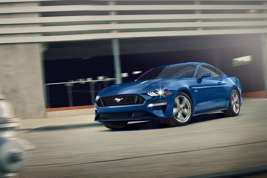 A 2023 Ford Mustang® GT Premium in Velocity Blue being driven out of a parking garage